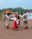 Family in Finno-Ugrian national dresses dance in a circle