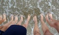 Family of five with bare feet on the shore of the sea and the wa Royalty Free Stock Photo