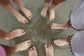 Family of five barefoot people on the sand in a circle on the be Royalty Free Stock Photo