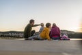 Family of five sitting on wooden pier