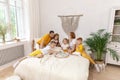 Family of five and their cat having breakfast in their bed in the morning Royalty Free Stock Photo