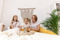 Family of five and their cat having breakfast in their bed in the morning Royalty Free Stock Photo