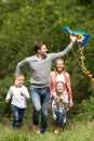 Family Flying Kite In Countryside