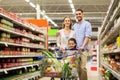 Family with food in shopping cart at grocery store Royalty Free Stock Photo