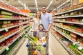 Family with food in shopping cart at grocery store Royalty Free Stock Photo