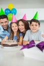 Family of four with cake and gifts at birthday party Royalty Free Stock Photo