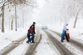 Family of four carefully crossing the street covered with snow and mud