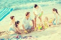 Family with four children playing together on sea beach Royalty Free Stock Photo