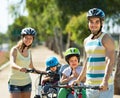 Family of four cycling on street Royalty Free Stock Photo