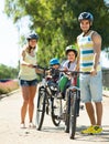 Family of four cycling on street Royalty Free Stock Photo