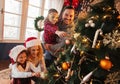 Family of four decorating a Christmas tree Royalty Free Stock Photo