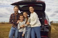 Portrait of happy mother, father and children by their car during road trip in autumn Royalty Free Stock Photo