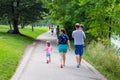 A family of four walks along the Lake of the Isles trail in Minneapolis