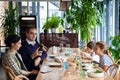 A family of four having a dinner in a restaurant. The father is pouring wine. Royalty Free Stock Photo