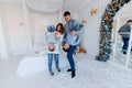 A family of four hugging in front of the christmas tree. love, happiness and big family concept Royalty Free Stock Photo