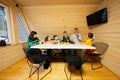 Family with four kids eat fruits in wooden country house on weekend. Father and son juggle tangerines