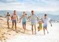 Family with four kids happily running on beach Royalty Free Stock Photo