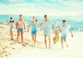 Family with four kids happily running on beach Royalty Free Stock Photo