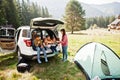 Family of four kids and mother at vehicle interior. Children sitting in trunk. Traveling by car in the mountains, atmosphere Royalty Free Stock Photo