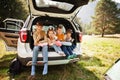 Family of four kids at vehicle interior. Children sitting in trunk. Traveling by car in the mountains, atmosphere concept Royalty Free Stock Photo