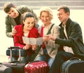 Family of four with luggage checking direction in map Royalty Free Stock Photo