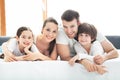 Family of four lying on bed Royalty Free Stock Photo