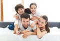 Family of four lying on bed Royalty Free Stock Photo
