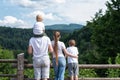 Family of four on nature background. Back view. Active rest