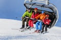 Family of four people riding on a chair ski lift