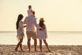 Family of four peoples with small daughters at sunset sea beach Royalty Free Stock Photo