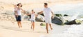 Family of four running on sandy beach on sunny weather Royalty Free Stock Photo