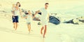 Family of four running on sandy beach on sunny weather Royalty Free Stock Photo