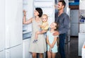 Family of four shopping new refrigerator in home appliance store