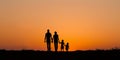 Family of four silhouette against orange sky Royalty Free Stock Photo