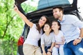 Family of four sitting in car trunk Royalty Free Stock Photo