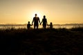 Family of four at sunset shadow black backlit Royalty Free Stock Photo