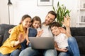 Family of four using laptop for video connection with grandparents or family Royalty Free Stock Photo