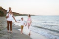 Family of four walking along the seashore. Parents and two sons. Happy friendly family Royalty Free Stock Photo