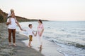 Family of four walking along the seashore. Parents and two sons. Happy friendly family Royalty Free Stock Photo