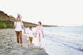 Family of four walking along the seashore. Parents and two sons. Happy friendly family Royalty Free Stock Photo