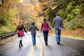 Family of four walking down a wet road holding hands.