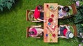 Family and friends eating together outdoors on summer garden party. Aerial view of table with food and drinks from above Royalty Free Stock Photo