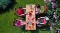 Family and friends eating together outdoors on summer garden party. Aerial view of table with food and drinks from above Royalty Free Stock Photo