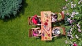 Family and friends eating together outdoors on summer garden party. Aerial view of table with food and drinks from above Royalty Free Stock Photo