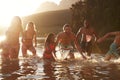 Family With Friends Enjoying Evening Swim In Countryside Lake Royalty Free Stock Photo