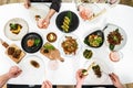 Family, friends gathering dinner. Hands of people eating roasted duck, dumplings, spring rolls, wok noodles, salads, vegetables,