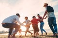 Family friends having fun on the beach at sunset - Fathers, mothers, children and uncles playing together - Focus on bodies - Love Royalty Free Stock Photo