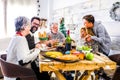 Family and friends at home eating and having fun during xmas eve celebration - table and decoration and cheerful happy people Royalty Free Stock Photo