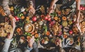 Family or friends praying holding hands at Thanksgiving celebration table