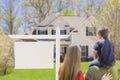 Family in Front of Blank Real Estate Sign and House Royalty Free Stock Photo